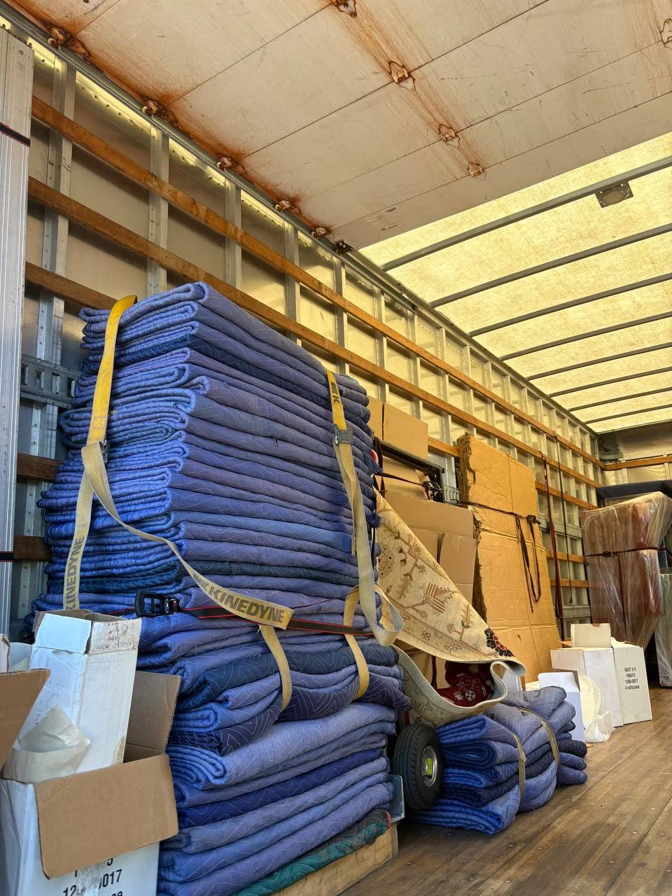 Moving blankets, dollies, and boxes secured inside a Raimond's Movers truck, included with every hourly rate